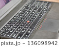 Closeup laptop keyboard with red trackpoint button detail. 136098942