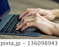 Hands typing on laptop keyboard closeup. 136098943