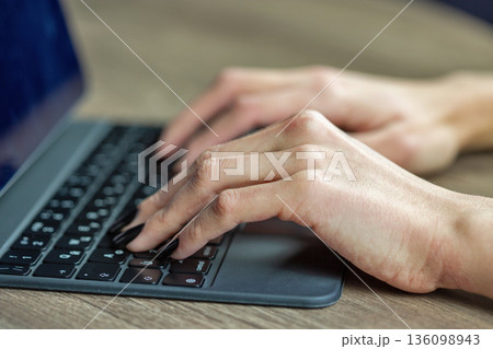 Hands typing on laptop keyboard closeup. Hands typing on laptop keyboard closeup. 136098943