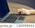 Female hand typing on laptop keyboard closeup. 136098944
