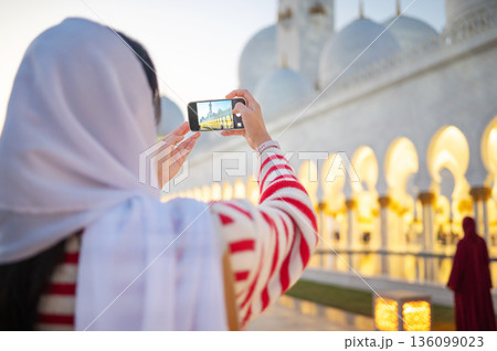 Woman Taking Photo with Smartphone at Sheikh Zayed Grand Mosque in Abu Dhabi United Arab Emirates Evening Woman Taking Photo with Smartphone at Sheikh Zayed Grand Mosque in Abu Dhabi United Arab Emirates Evening 136099023