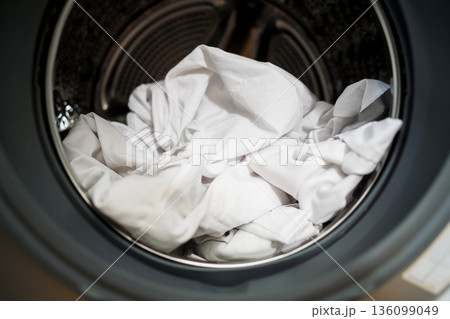 Daily chores. Smart appliances. White clothes from washing machine at home, closeup of washing machine drum with open door Daily chores. Smart appliances. White clothes from washing machine at home, closeup of washing machine drum with open door 136099049