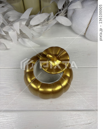 A gypsum box in the shape of a pumpkin. Golden color. The box lid is slightly open. Decorative gypsum products. On white boards. A gypsum box in the shape of a pumpkin. Golden color. The box lid is slightly open. Decorative gypsum products. On white boards. 136100005