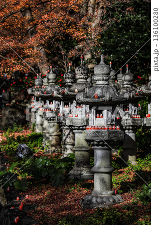 Symbol of determination, good luck charm in Japanese, Many traditional red Daruma doll on stone lantern at Katsuo-ji temple, Osaka, Japan. 136100280