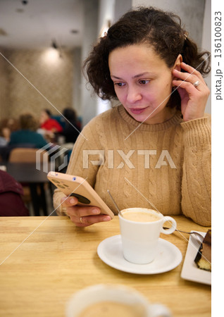Woman In Cozy Sweater Using Phone In Cafe With Coffee And Cake Woman In Cozy Sweater Using Phone In Cafe With Coffee And Cake 136100823