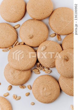 Peanut macarons flat lay on white background, minimal sweet dessert Peanut macarons flat lay on white background, minimal sweet dessert 136100902
