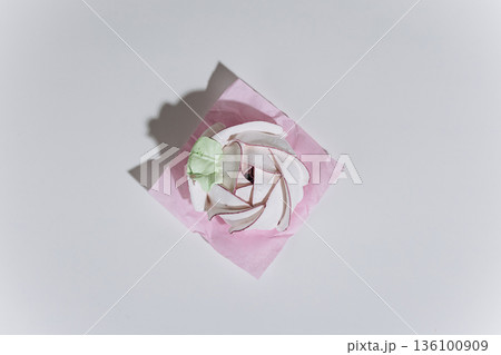 Meringue swirl dessert on pink parchment, minimal flat lay with hard shadow Meringue swirl dessert on pink parchment, minimal flat lay with hard shadow 136100909