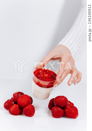 Hand holding strawberry panna cotta dessert cup with fresh berries on white background Hand holding strawberry panna cotta dessert cup with fresh berries on white background 136100913