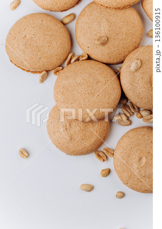 Peanut macarons flat lay on white background, minimal dessert texture 136100915