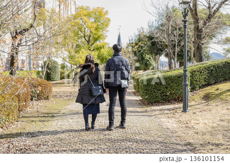 秋の公園を歩く親子 136101154