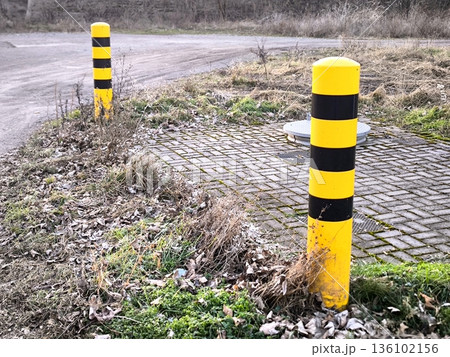 Yellow and black warning posts on the side of the road Yellow and black warning posts on the side of the road 136102156