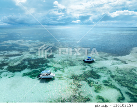 Aerial view of two motorboats anchored in clear turquoise water 136102157
