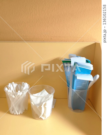 Cotton swabs, wipes and spatulas in plastic cups on a shelf Cotton swabs, wipes and spatulas in plastic cups on a shelf 136102158