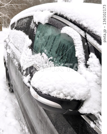 A black car covered in a layer of fresh snow 136102173