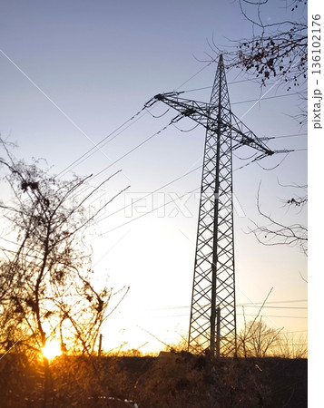 High-voltage power line tower against the backdrop of sunset 136102176