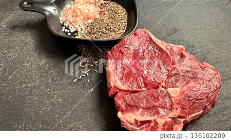 Raw Beef With Bold Seasoning In Skillet, Uncooked Steak Adjacent To Spicy Cast Iron Surface, Uncooked Cut Of Beef Beside Seasoned Cast Iron Pan With Salt And Spices 136102209