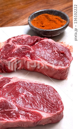 Steaks Seasoned Vividly, Grilled Ribeye With Bold Spices, Homecooked Steaks Seasoned With Vibrant Spices, Casual Barbecue Scene Featuring Marbled Ribeye Steaks Seasoned Vividly 136102222