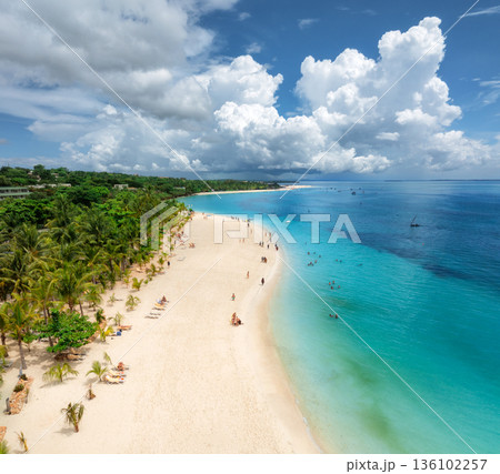 Aerial view of tropical sandy beach, blue sea and rain clouds 136102257