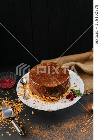 Chocolate glaze cake on stand with cocoa dust, berries and mint on dark background Chocolate glaze cake on stand with cocoa dust, berries and mint on dark background 136102878