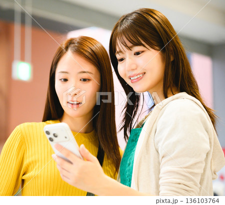 女性二人でスマホを見る ■撮影協力:関西国際空港(KIX) 女性二人でスマホを見る ■撮影協力:関西国際空港(KIX) 136103764