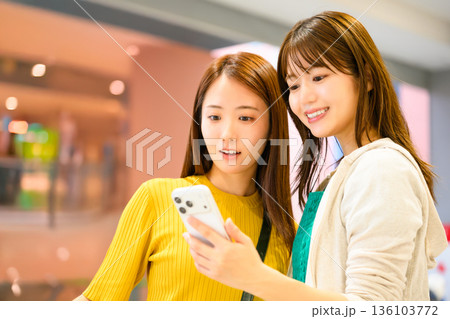 女性二人でスマホを見る _■撮影協力：関西国際空港（KIX） 136103772
