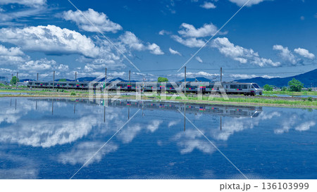 澄みきった青い空と白い雲の間を駆け抜けるJR九州の特急みどり 136103999