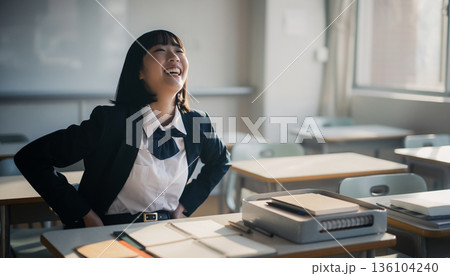 教室で成績アップに喜ぶ制服姿の女子高生。ガッツポーズと笑顔の合格・成功イメージ 136104240