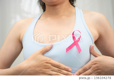 Breast cancer, pink ribbon at Asian senior lady for supporting awareness, symbol of World Breast Cancer Day. 136104278