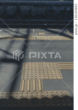 駅の点字ブロック 触知案内の床面 影が落ちる構図 136104665