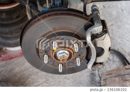 Close up of a car wheel and disc brake while waiting for repair in garage. 136106102