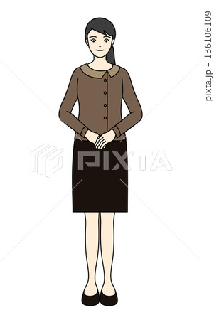 落ち着いた茶色の制服で前を合わせ丁寧に立つ女性スタッフ 136106109
