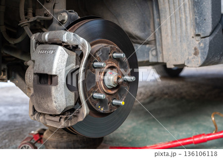 Close up of a car wheel and disc brake while waiting for repair in garage. 136106118