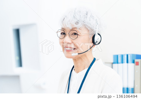 インカムを付けて働くシニア女性 インカムを付けて働くシニア女性 136106494