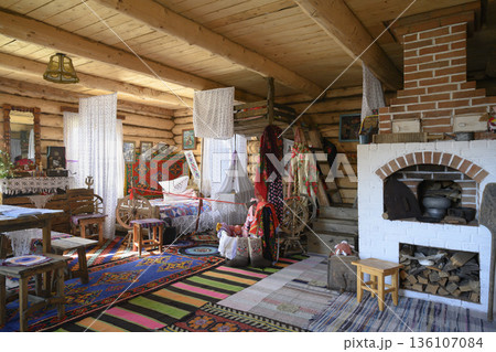 Interior of a 19th-century Russian hut with big oven, bed and cradle suspended from the ceiling 136107084