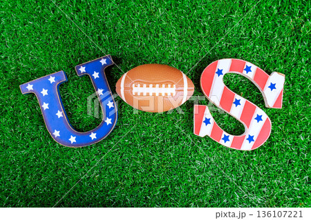 Letters U S football sit on green grass, for super bowl sports event decoration for game day. Letters U S football sit on green grass, for super bowl sports event decoration for game day. 136107221