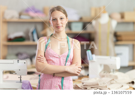 Young woman seamstress invites to the workshop 136107559