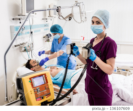 Doctors give resuscitation to a male patient in the emergency room. 136107609