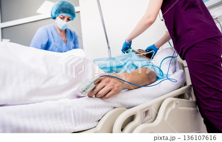 Doctors give resuscitation to a male patient in the emergency room. 136107616