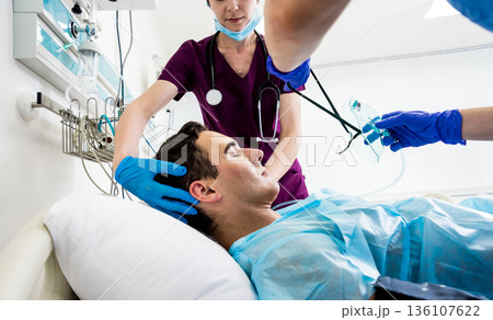 Doctors give resuscitation to a male patient in the emergency room. 136107622