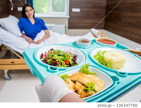 Nurse in medical coat is holding a tray with breakfast Nurse in medical coat is holding a tray with breakfast 136107780