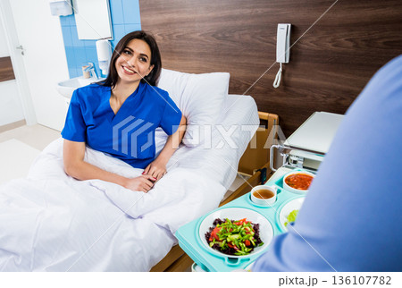 Nurse in medical coat is holding a tray with breakfast  136107782