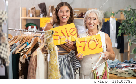 Elderly and young women choose discounted clothes in store Elderly and young women choose discounted clothes in store 136107786