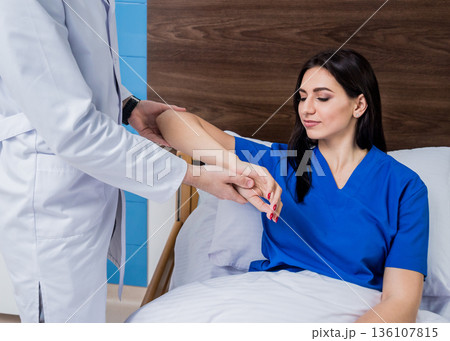 Traumatologist examining patient hands in modern hospital Traumatologist examining patient hands in modern hospital 136107815