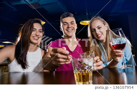 Cheerful friends in the pub. Drinking beer, wine and whisky Cheerful friends in the pub. Drinking beer, wine and whisky 136107954