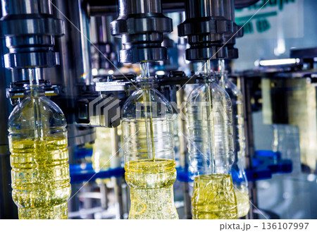Bottling line of sunflower oil in bottles. Vegetable oil production plant Bottling line of sunflower oil in bottles. Vegetable oil production plant 136107997