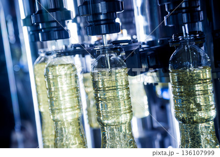 Bottling line of sunflower oil in bottles. Vegetable oil production plant Bottling line of sunflower oil in bottles. Vegetable oil production plant 136107999
