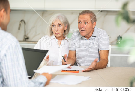 Elderly couple discussing deal with male salesman Elderly couple discussing deal with male salesman 136108050