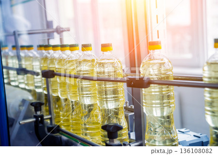 Bottling line of sunflower oil in bottles. Vegetable oil production plant Bottling line of sunflower oil in bottles. Vegetable oil production plant 136108082