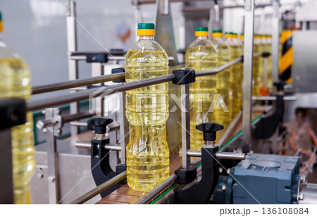 Bottling line of sunflower oil in bottles. Vegetable oil production plant Bottling line of sunflower oil in bottles. Vegetable oil production plant 136108084