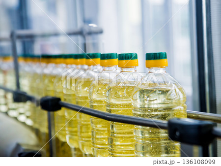 Bottling line of sunflower oil in bottles. Vegetable oil production plant Bottling line of sunflower oil in bottles. Vegetable oil production plant 136108099